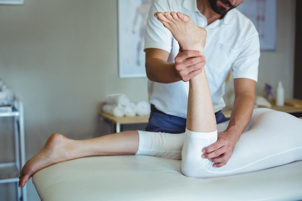 膝の関節角度を計測する理学療法士